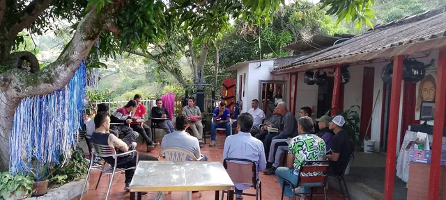 Grupo reunido en círculo en la finca, al aire libre