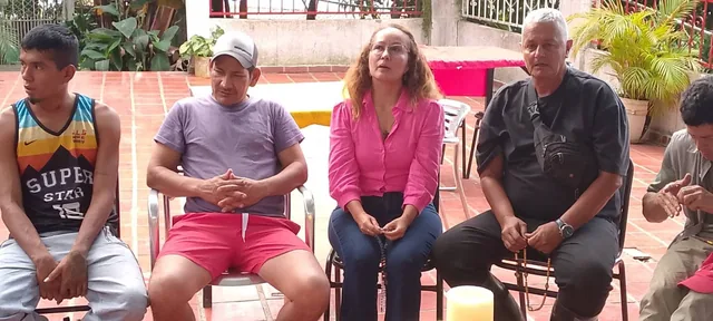 Tres familiares sentados en el patio de la finca, compartiendo el rosario